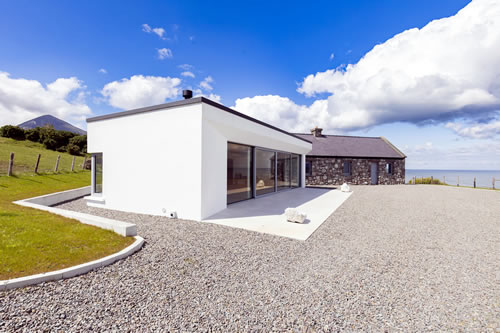 Exterior of property with grounds, sea and mountain in background